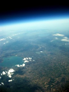 Il lago Trasimeno (a sinistra), il lago di Bolsena (verso l'orizzonte) e la scia di un aereo (in basso a destra). Quota: 18.400 m